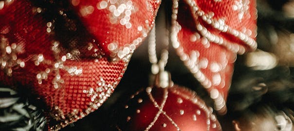 Close-up of a festive red Christmas ornament with gold accents on a decorated tree.